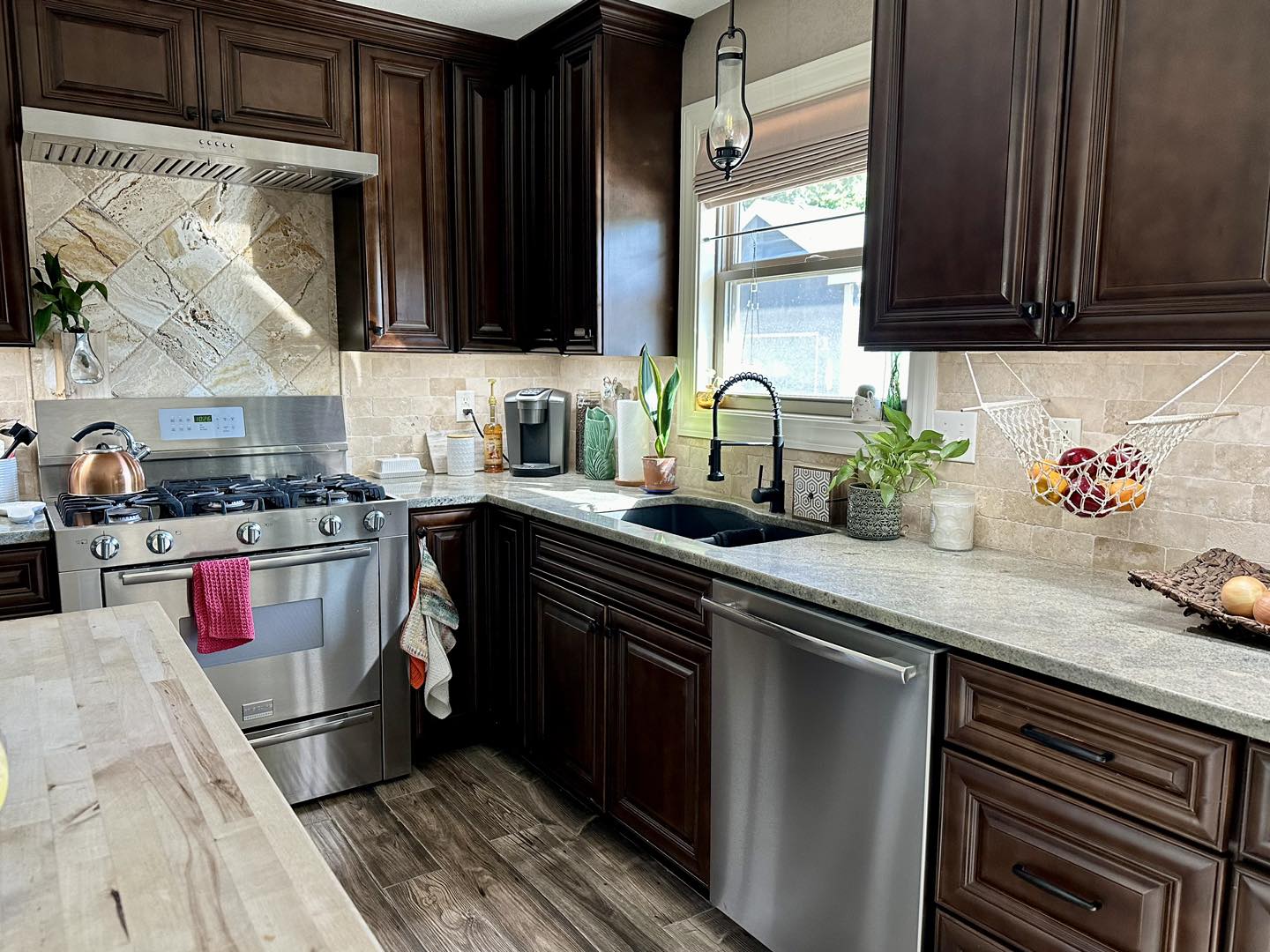 Tan and brown kitchen setting with chrome appliances.