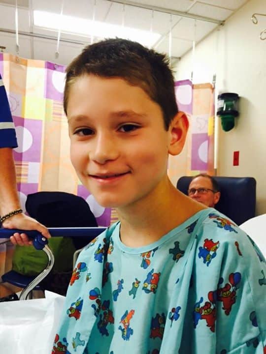 Smiling male child in a hospital room setting.