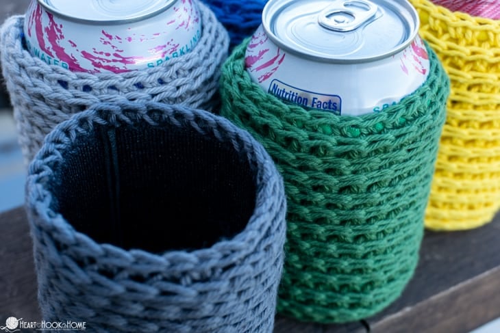Three Crochet Coozie Cover pattern with aluminum cans inserted in two of them. 