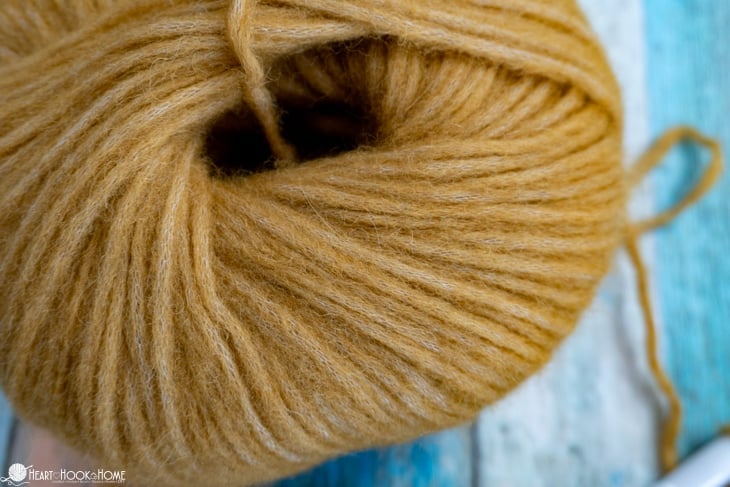 Up close of a skein of gold colored Wonderfluff Yarn from WeCrochet.