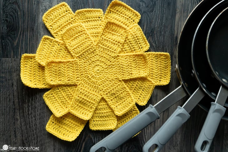Small, Medium, Large, and X-Large examples of the Crochet Pan Protectors Pattern, in a yellow colorway, stacked on top of each other.