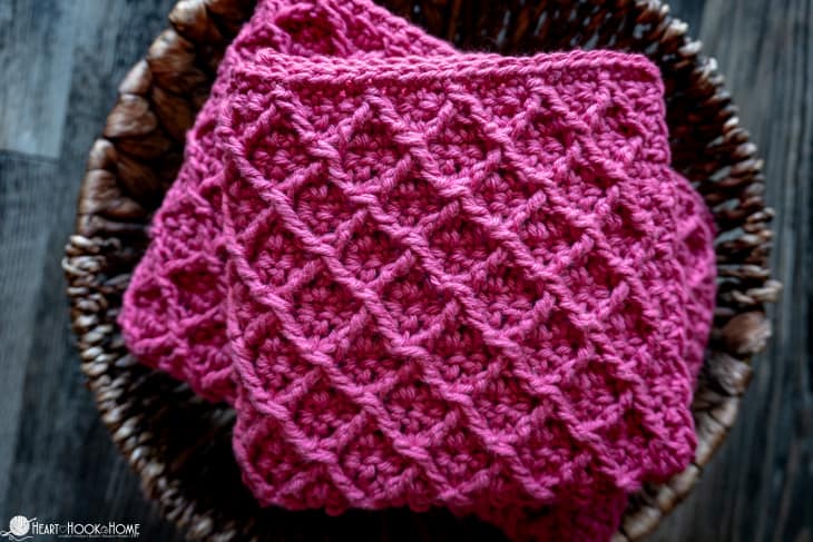 Pink colorway of the Diamond Cloth crochet pattern in three sizes sitting in a basket.