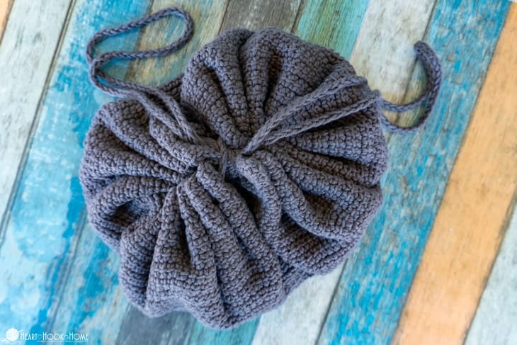 Example of a tied shut, gray Drawstring Cosmetics Bag crochet pattern.