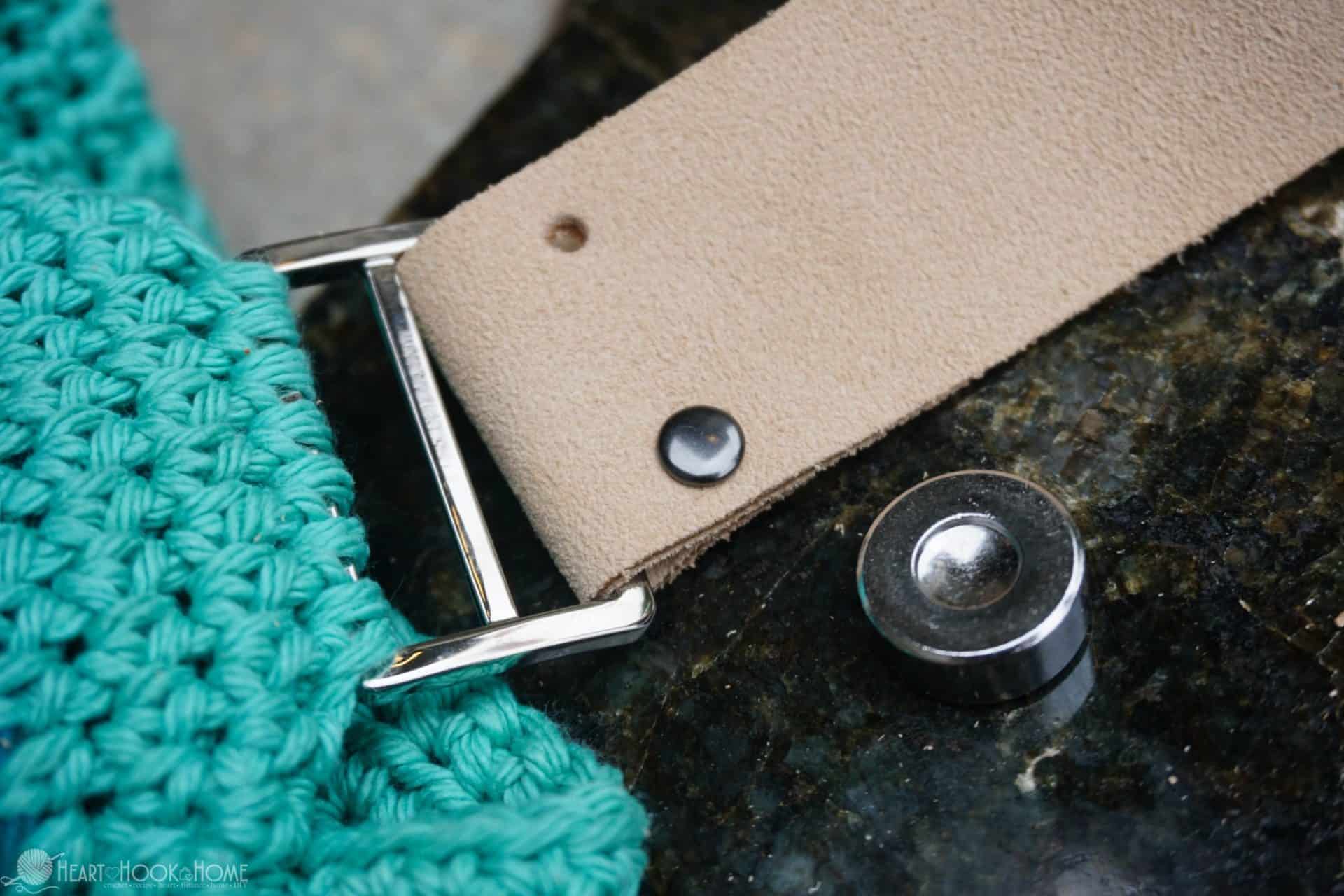 Double Cap Rivets being set in leather on the strap of an example of the Life's a Beach Bag crochet pattern.