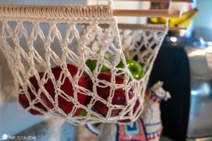 Example of a Fruit Hammock crochet pattern in a white colorway with apples nestled in it.