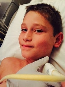 Smiling male child in a hospital bed.