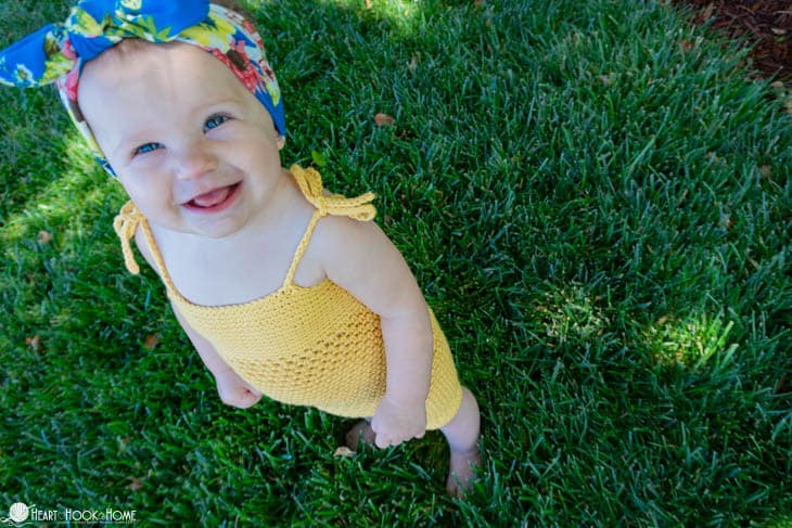 Yellow example of the Rockin' Romper crochet pattern on a smiling toddler.