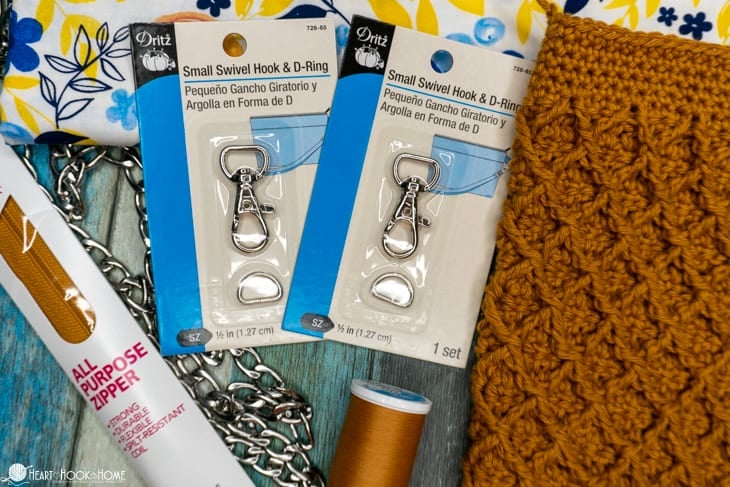 Supplies gathered for the Girl\'s Best Friend Crossbody Purse next to a gold colorway sample of the purse.