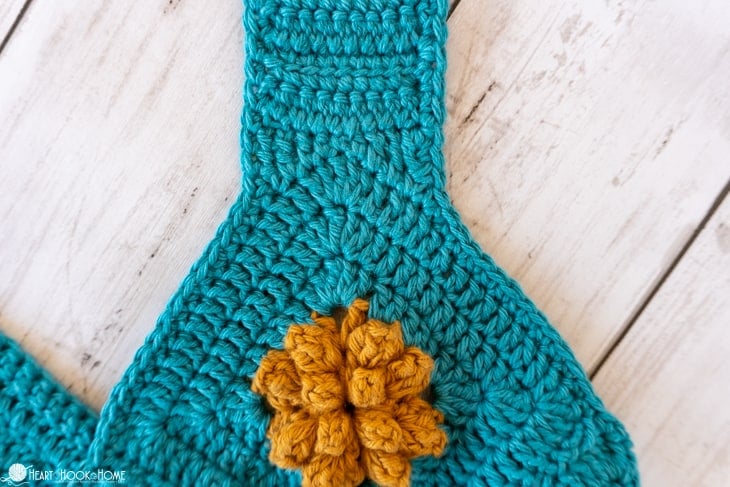 Up close of the strap of the Marigold Sling Bag crochet pattern in blue and gold.