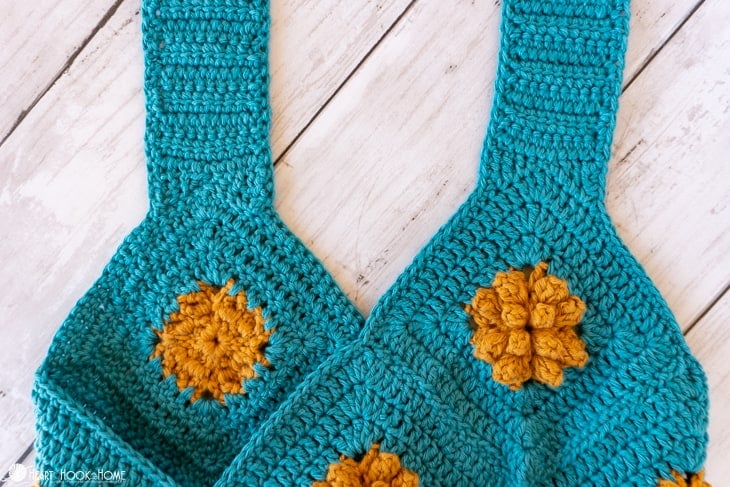 Up close of the straps of the Marigold Sling Bag crochet pattern in blue and gold.