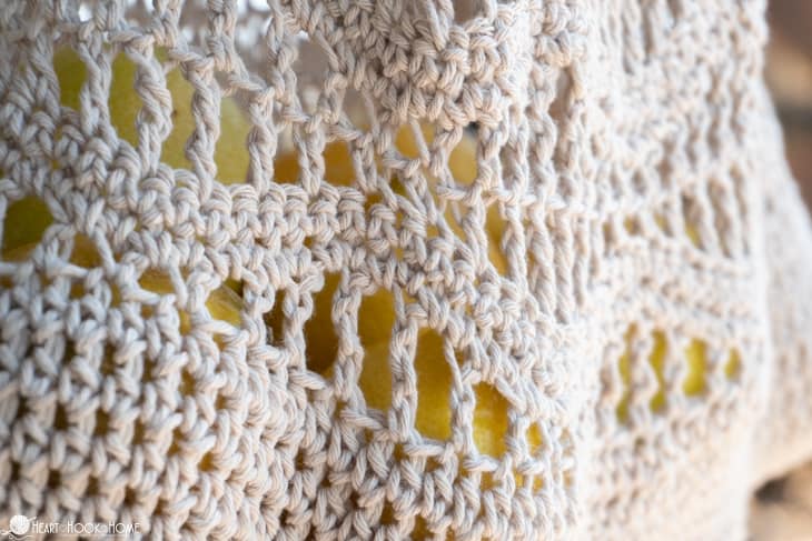 White example of the Wave Market Bag Crochet Pattern holding lemons.