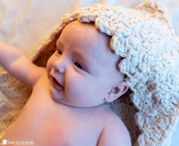 Example of a neutral tone of the Newborn Hooded Towel Crochet Pattern on a smiling baby.
