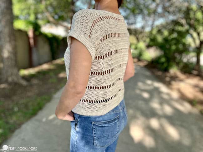 Back of the Godiva Tee on a female model wearing jeans in a park.