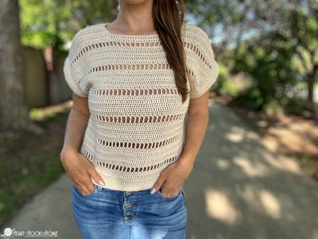 Peep style Godiva Tee on a female model wearing jeans in a park.