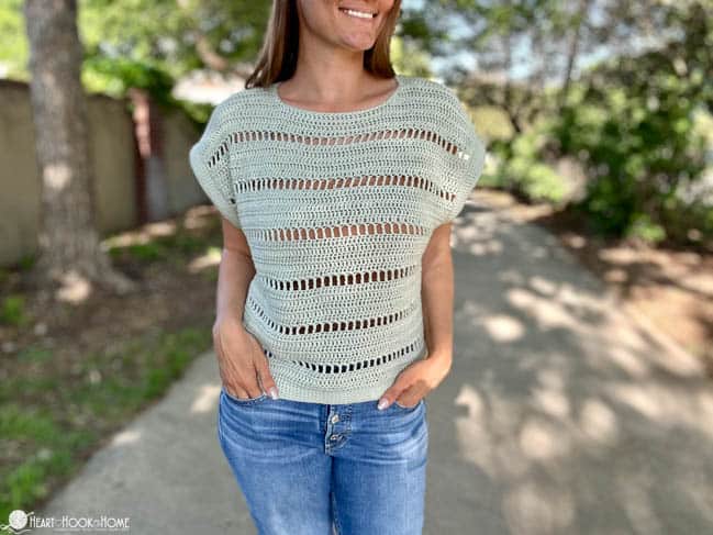 Partially see through Godiva Tee on a female model wearing jeans in a park.