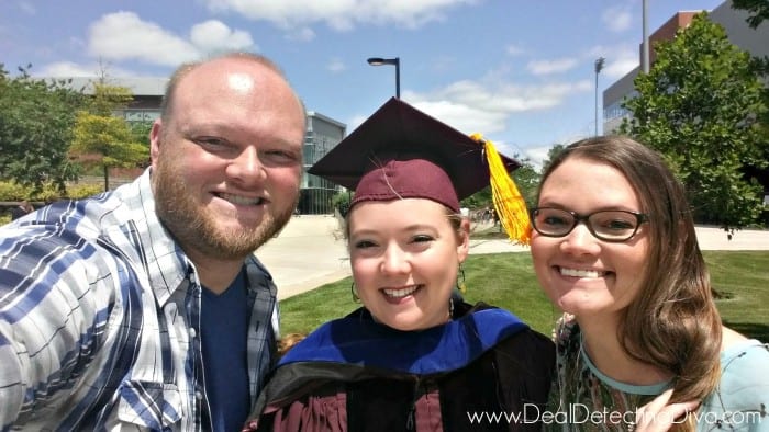 Smiling female college graduate posing with her brother and sister.