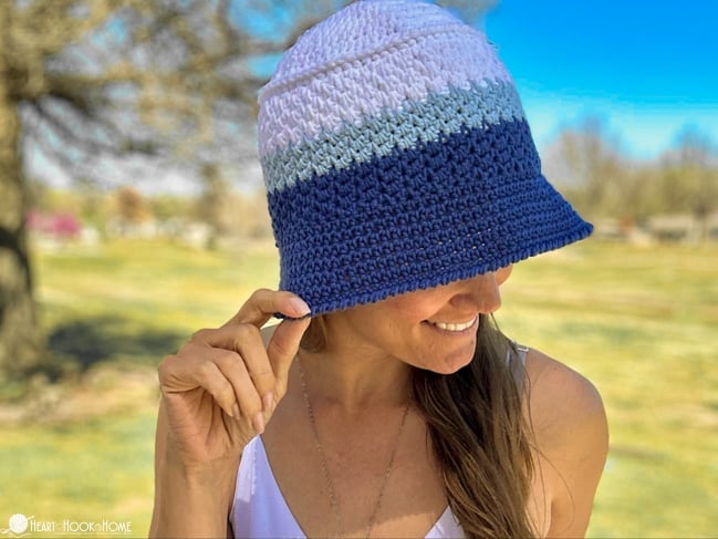 The Sports Team Bucket Hat in Kansas City Royals colors on a smiling female model in a park setting.