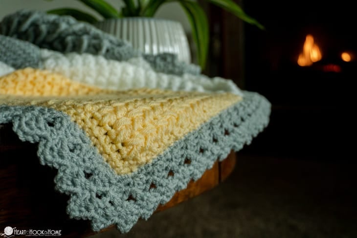 Up close of the border on a silver, white, and gold example of the Crochet Stitch Sampler Afghan Pattern.