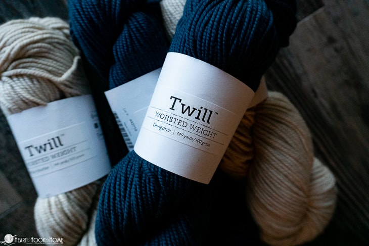 Skeins of Twill worsted weight yarn skeins in the Horchata Heather and Dungaree colorways.